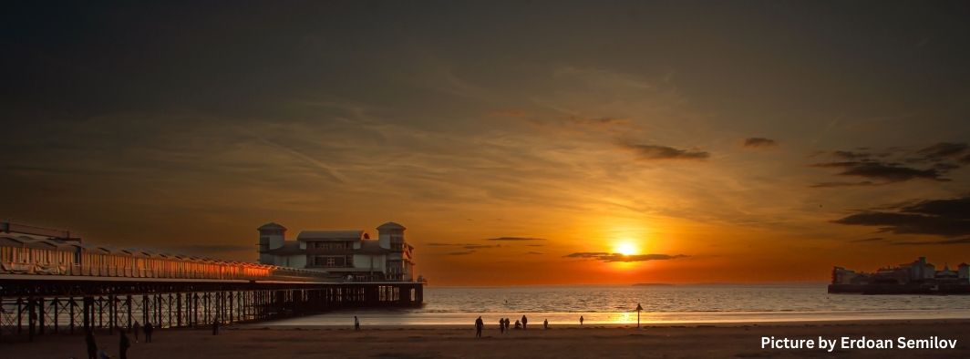 People on Weston-super-Mare-beach near the Grand Pier watching a sunset out to sea